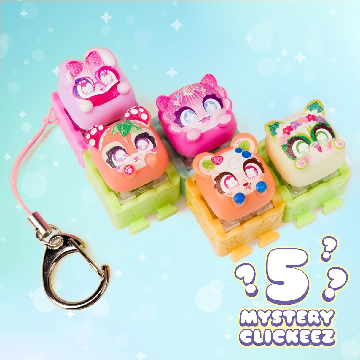 Five colorful cartoon-shaped clickers with a metal clasp keychain on a light blue background with the text '5 MYSTERY CLICKEEZ'.