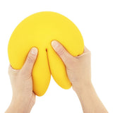 Yellow fortune cookie squishy toy squeezed in hands, jumbo slow-rise sensory fidget toy