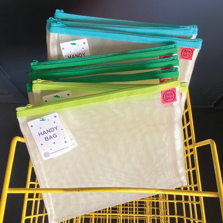 Set of colorful pouches with labels on a yellow metal frame against a dark background