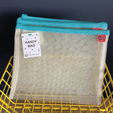 Mesh handy bag with blue zipper on a yellow grid background