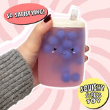 Hand holding the Boba Squish-Tea squishy showing full cup shape with tapioca bubbles and straw
