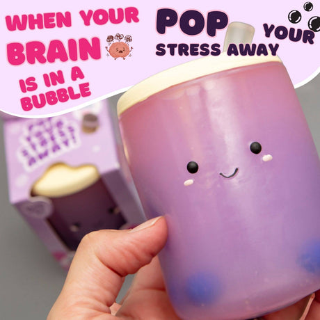 Hand holding the Boba Squish-Tea kawaii squishy with purple packaging visible in background