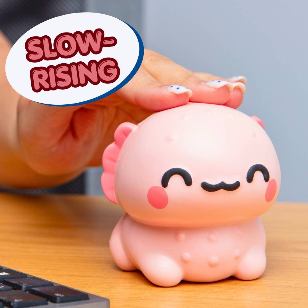 A pink cartoonish squishy toy with a smiling face sits on a wooden desk, with a hand pressing down on its head. A speech bubble in the top left says 'SLOW-RISING'.