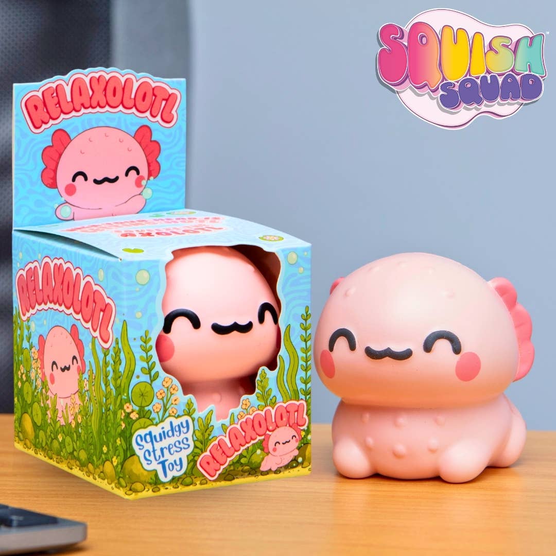 A pink axolotl-shaped squishy toy shown next to its blue illustrated retail box on a wooden surface, with a 'Squish Squad' logo in the top right.