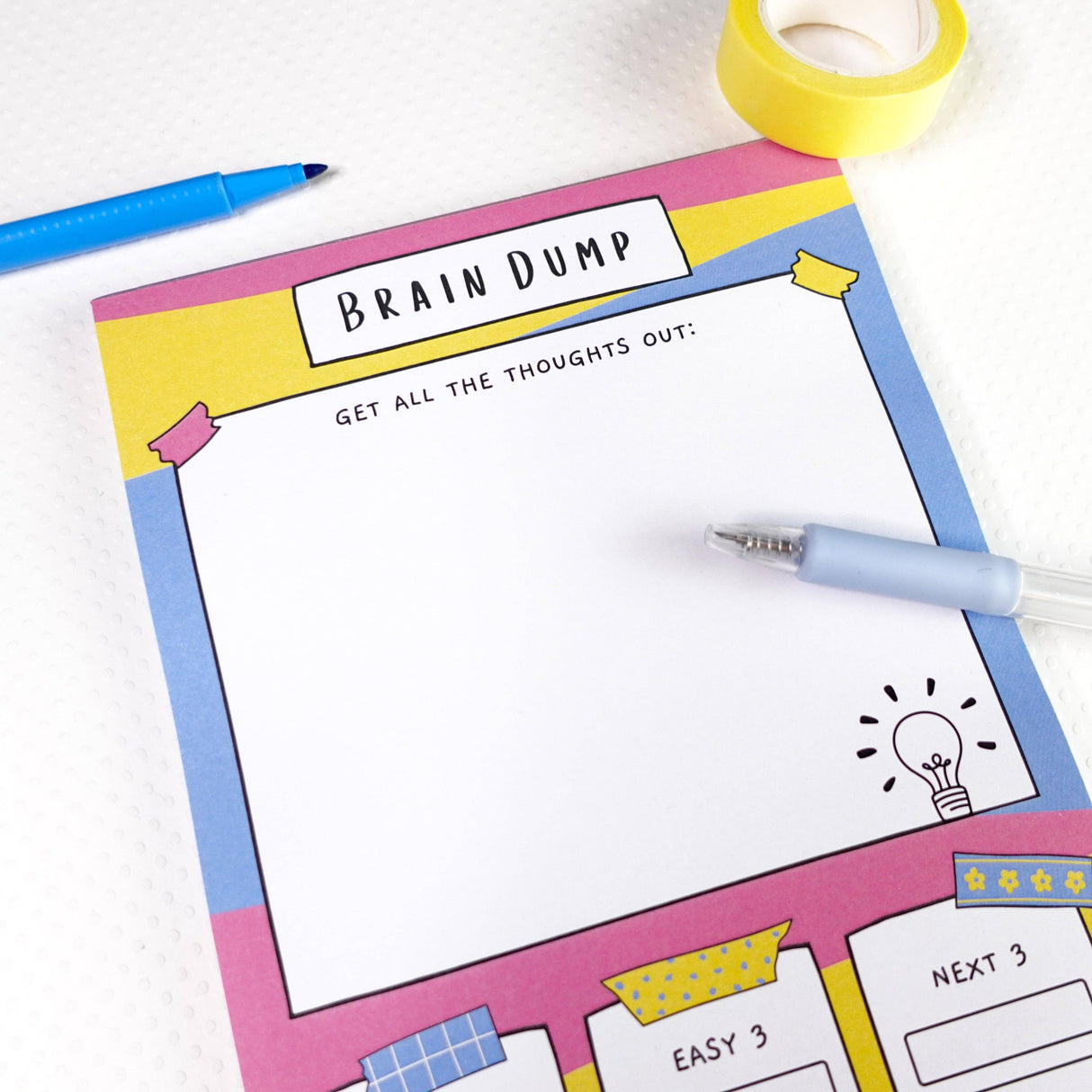 Brain dump notepad angled view showing writing section, pink blue yellow stationery