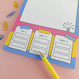 Brain dump notepad task columns with colourful paperclip styling detail