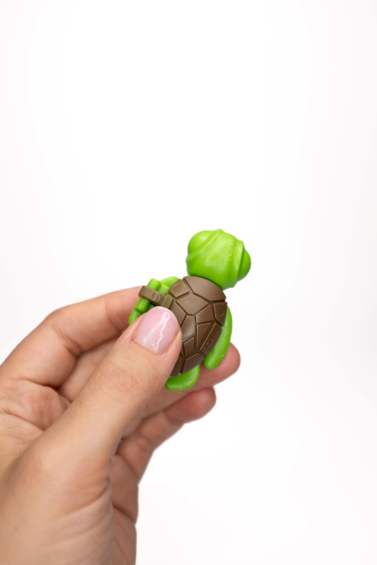 Green Calm Buddi Turtle sensory fidget toy held in hand, front view