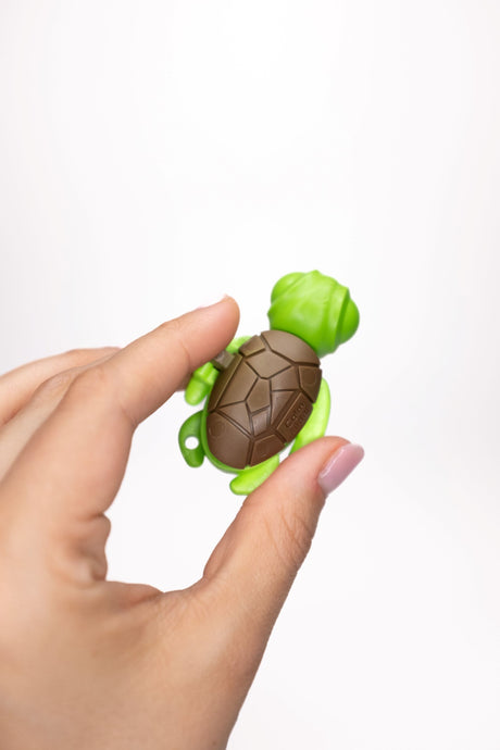 Green Calm Buddi Turtle sensory fidget toy held in hand, top-down view