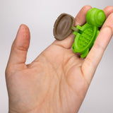 Green Calm Buddi Turtle open in palm showing spiky cavity, sensory toy
