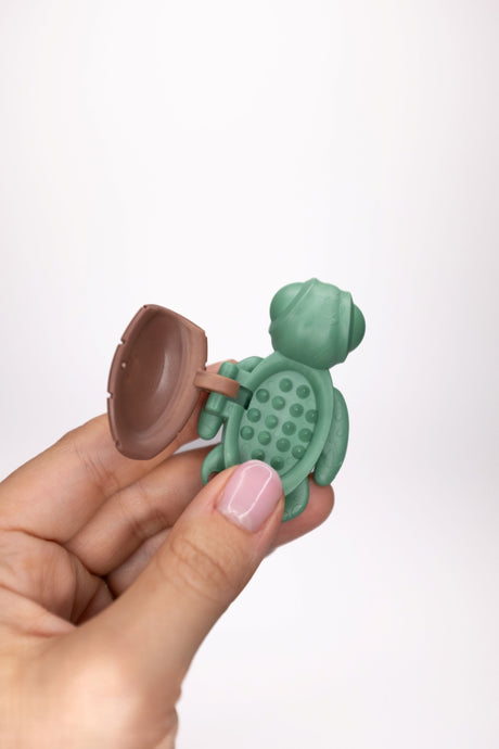 Sage green Calm Buddi Turtle held open, spiky inner shell sensory fidget