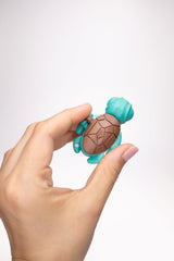 Teal Calm Buddi Turtle sensory fidget toy held in hand, top-down view