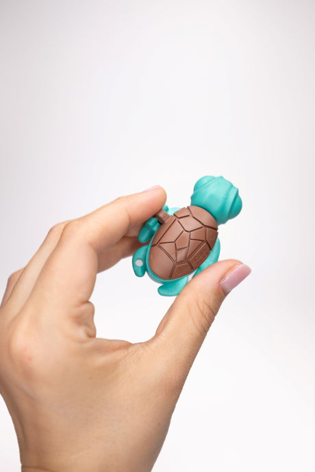 Teal Calm Buddi Turtle sensory fidget toy held in hand, top-down view