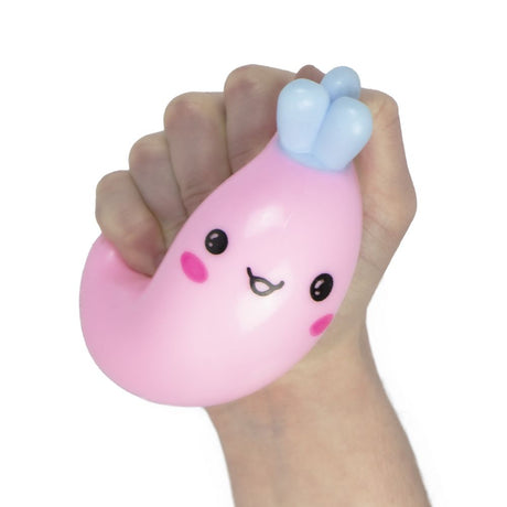 Hand squeezing a pink candy carrot squishy toy