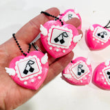 Pink glitter 3D printed heart clicker fidget keychain held in a palm showing pixel art cherry design and white wings