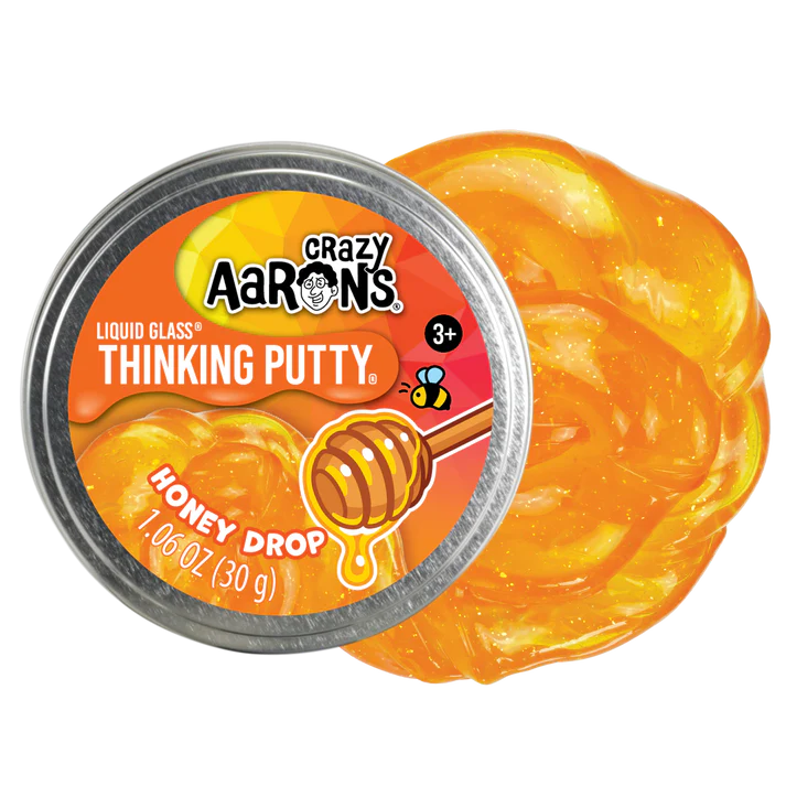 Crazy Aaron's Honey Drop Liquid Glass Thinking Putty mini tin beside its amber gold swirl