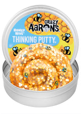 Crazy Aaron's Honey Hive Thinking Putty open tin showing golden amber glitter putty with bee confetti and honeybee-themed lid artwork