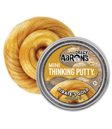 A tin of Crazy Aaron's Mini Thinking Putty in 'Pirate's Gold' shown next to a large, coiled piece of the golden glittery putty on a plain white background.