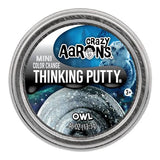 A round metal tin of Crazy Aarons Mini Color Change Thinking Putty in the Owl flavor, featuring a blue and black space-themed label with an owl graphic.