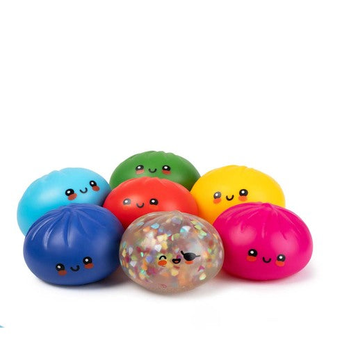 A group of seven cute, kawaii-style squishy stress toys shaped like dumplings, arranged on a clean white background. The set includes six solid-colored dumplings in blue, light blue, green, red, yellow, and pink, plus one clear, glitter-filled dumpling in the center.