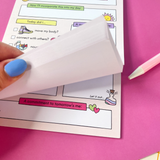 Daily Focus notepad pages being fanned, showing multiple sheets, pastel planner