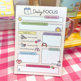 Daily Focus notepad displayed in shop setting, pastel mental wellness stationery