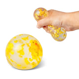 Hand holding and squeezing a clear duck squish ball next to a resting ball to show size comparison