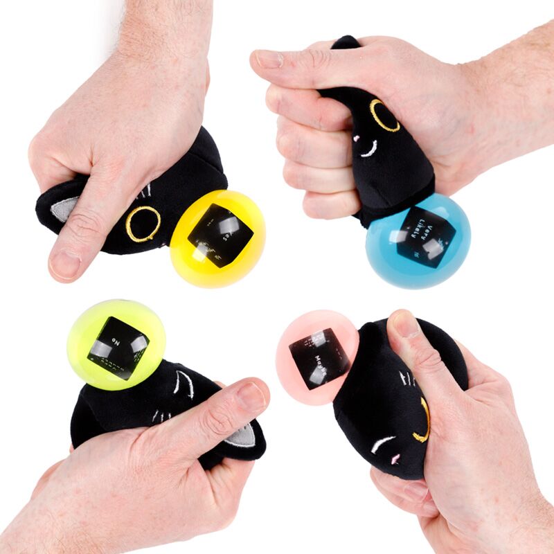 Hands squeezing Fortune Squeezies Lucky the Black Cat magic fortune teller plush squeezy toy showing four different coloured magic fortune dice balls in yellow, blue, green and pink