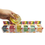 Hand holding a colorful slime above shelves with variously colored slimes in boxes.