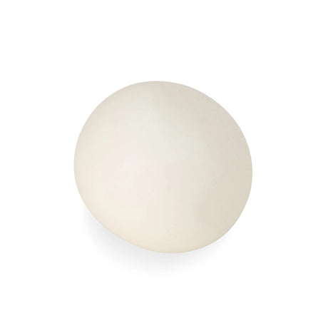 Glow in the dark squish ball in daylight showing its soft off-white appearance on a white background