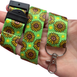 Happy Sunflowers kawaii lanyard looped in an adult palm on a white background showing safety breakaway clasp, swivel clip and full smiling sunflower print