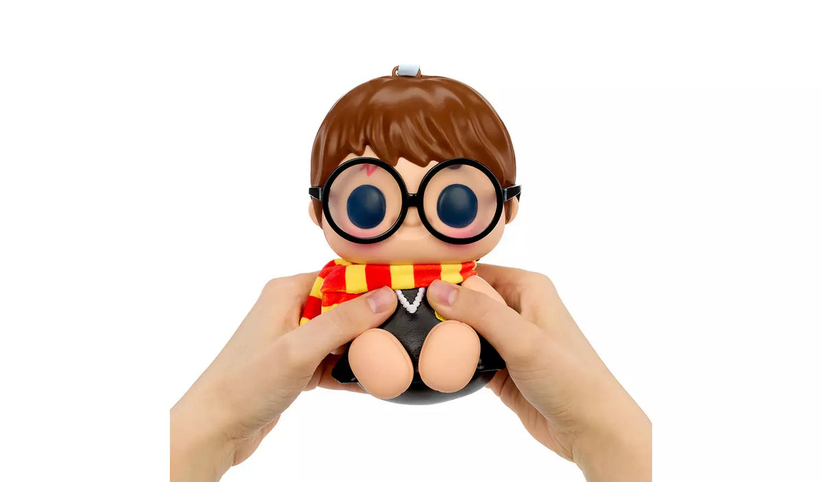 Hands squeezing Hyojo Harry Potter squishy figure with round glasses, plush scarf and robe