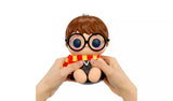 Hands squeezing Hyojo Harry Potter squishy figure with round glasses, plush scarf and robe