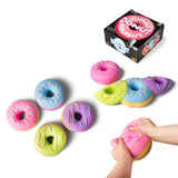 All four jumbo donut squishy designs displayed together alongside retail box and hands squeezing pink variant