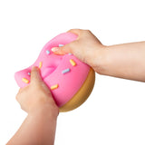 Pink jumbo donut squishy being squeezed with both hands to demonstrate squishiness