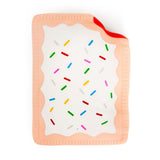 Flat lay of a jumbo peach pink squishy Pop-Tart with white icing drizzle and colourful sprinkles