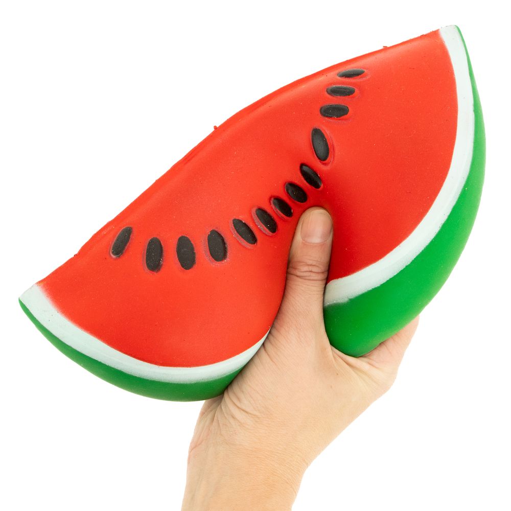 One hand holding a jumbo watermelon slice squishy toy to show size
