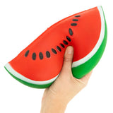One hand holding a jumbo watermelon slice squishy toy to show size