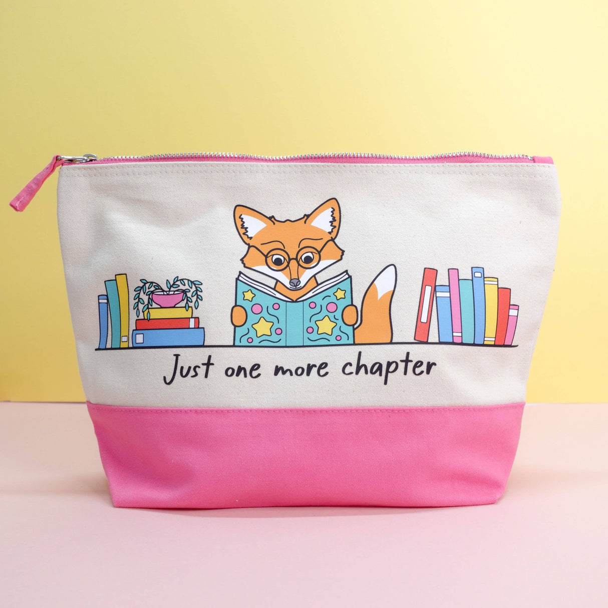 Just One More Chapter fox canvas pouch displayed upright against a yellow background showing full Maple the Fox bookshelf illustration and pink zip