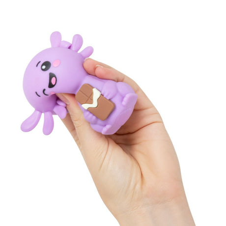 Hand squeezing a purple Squish Sweetolotl axolotl squishy fidget toy holding a chocolate bar