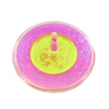 Close-up overhead view of pink and yellow Lava Storm liquid spinner in motion on black surface