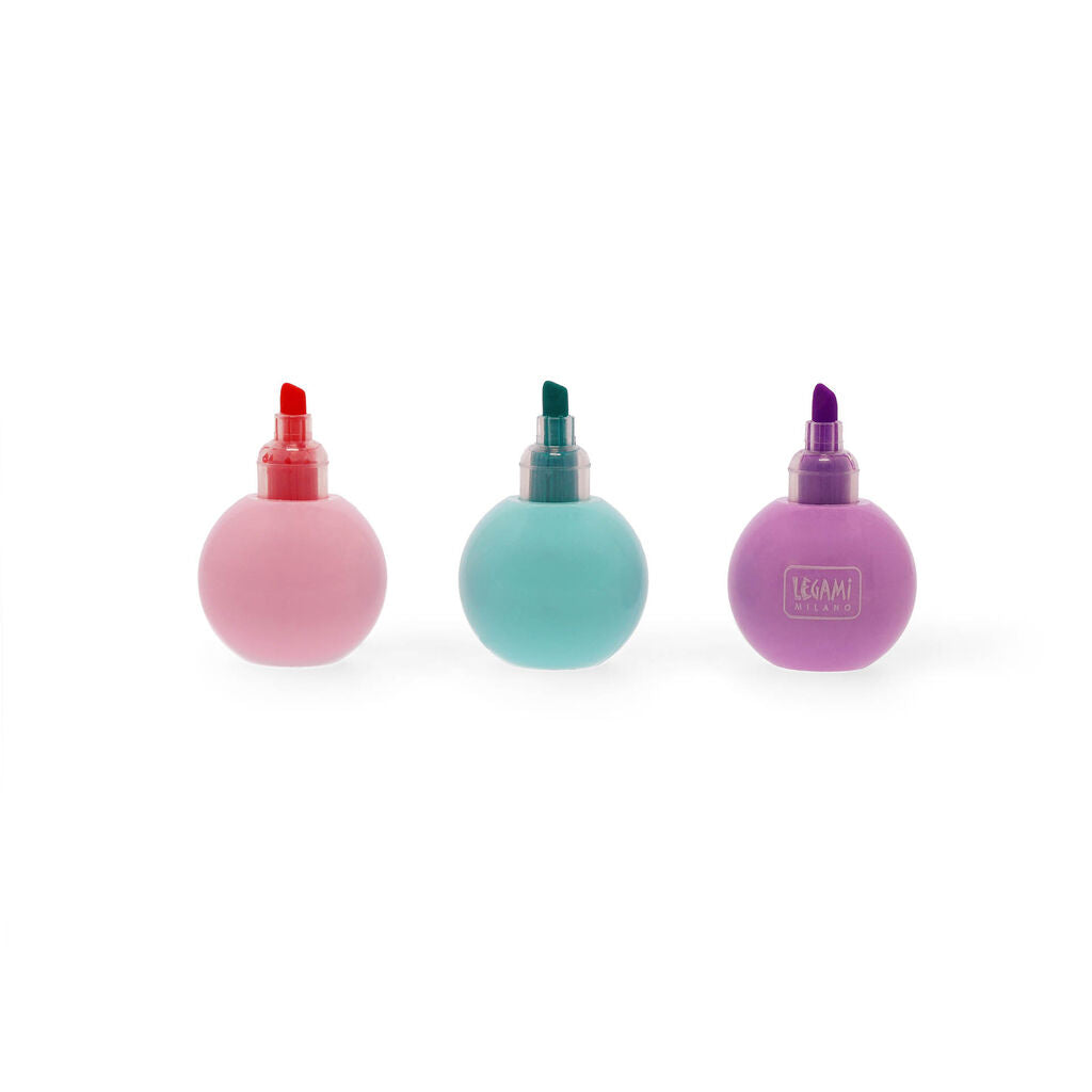 Three pastel ball shaped highlighters in pink, teal and purple standing separately with visible chisel tips