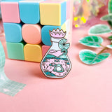 Lula Rocks Bottled Frog UV Glow enamel pin, purple lavender colorway, blocks props