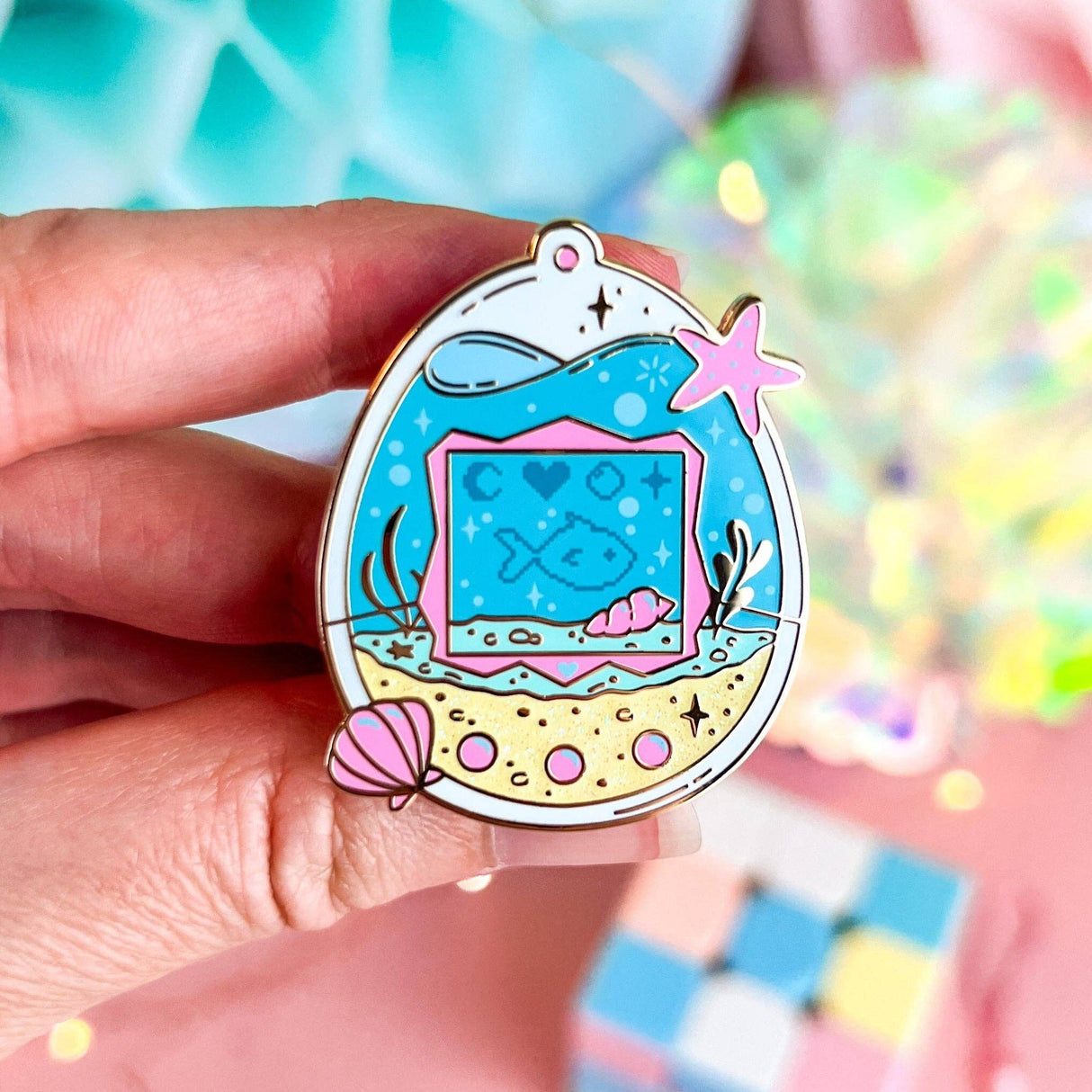 Lula Rocks Digital Aquarium enamel pin, blue pink ocean tamagotchi design, hand-held