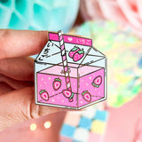 Lula Rocks Strawberry Milk kawaii enamel pin, pink ichigo carton, hand-held close-up