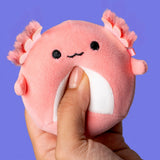 Hand squeezing pink Archie the Axolotl MallowMees by Squishmallows weighted plush