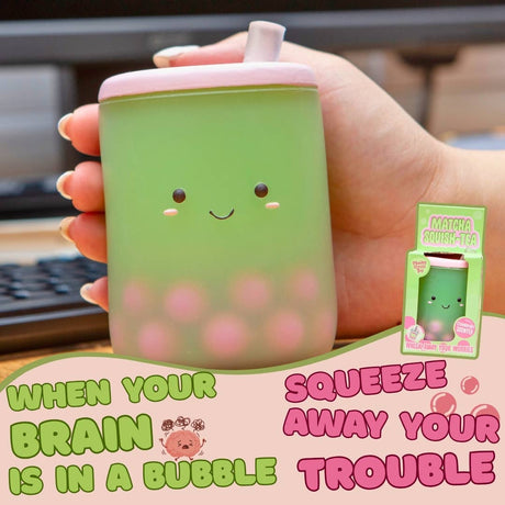 Hand holding Matcha Squish-Tea boba squishy stress toy at a desk