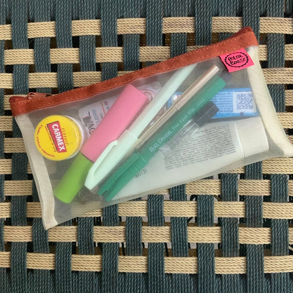 transparent mesh pencil pouch with brown zip holding pens highlighters and carmex