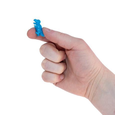 Adult thumb holding a tiny blue T-rex micro dinosaur fidget