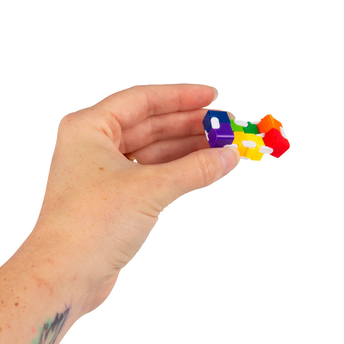 Adult hand holding a rainbow infinity cube fidget between finger and thumb