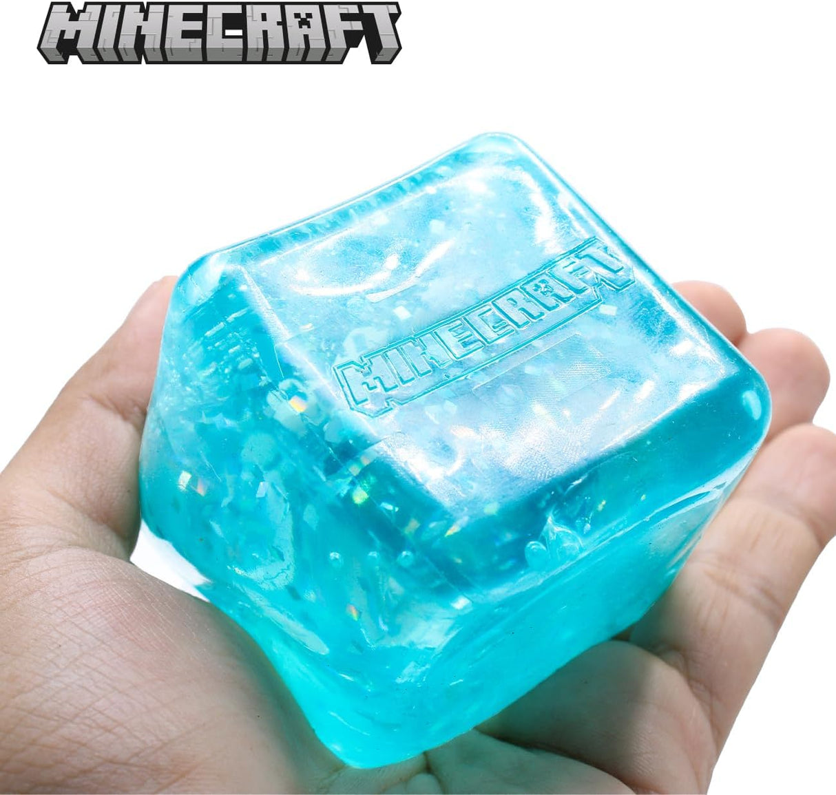 Teal Minecraft Jelly SquishMe cube held in hand, glitter squishy fidget toy
